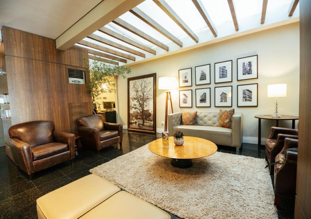 弗洛里亚诺波利斯伊利亚港口酒店的客厅配有桌子和皮椅