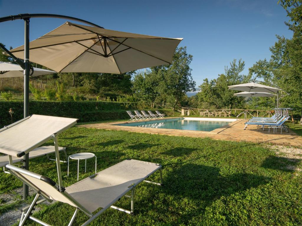 萨尔纳诺Agriturismo Serpanera的一个带桌子、遮阳伞和椅子的游泳池