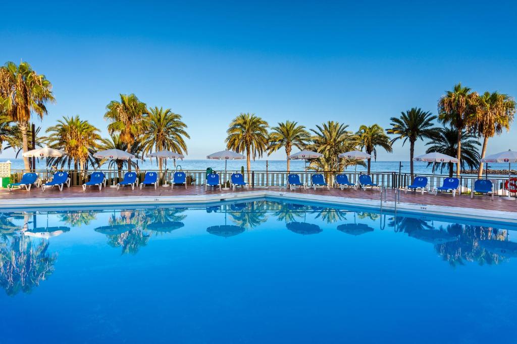美洲海滩索尔特内里费岛酒店的棕榈树和大海的游泳池