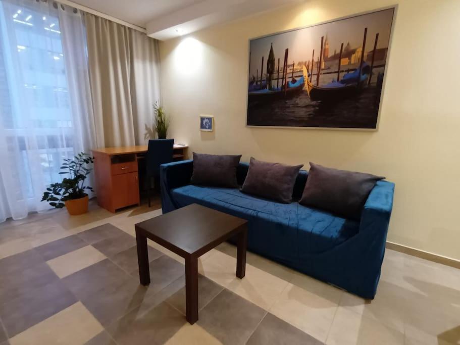 华沙Apartament Pereca 2的客厅配有蓝色的沙发和桌子