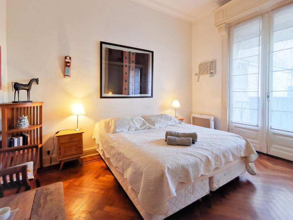布宜诺斯艾利斯阿里巴大街住宿加早餐酒店的一间卧室配有一张床、一张桌子和两盏灯。