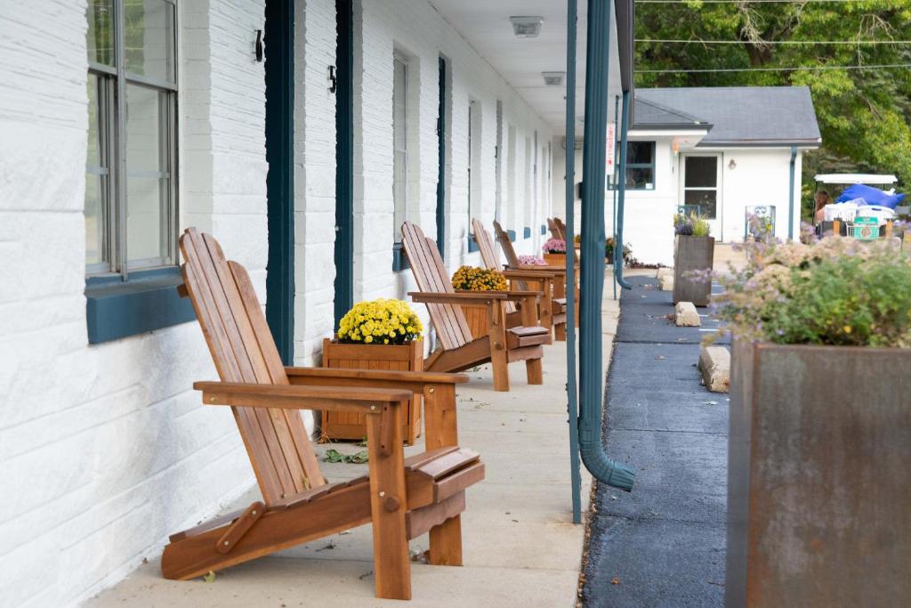 密歇根城Al & Sally's Motel的坐在大楼外的一排木椅