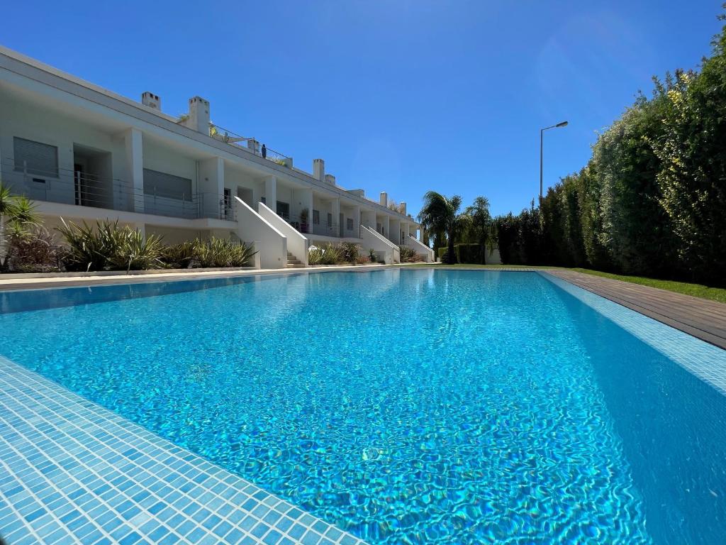 阿尔布费拉Albufeira Lux Apartment的一座大型蓝色游泳池,位于大楼旁边