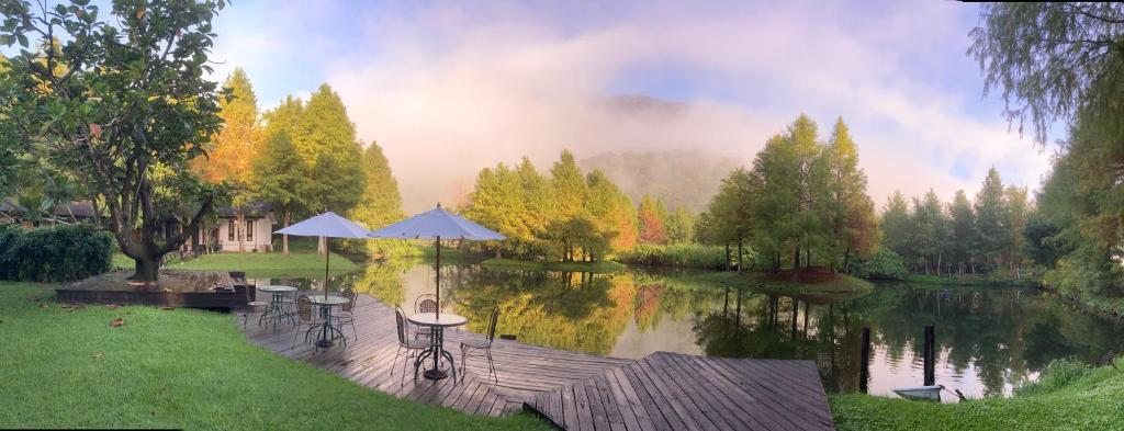 Fengshan 葛莉丝庄园的享有湖景,配有桌子和遮阳伞