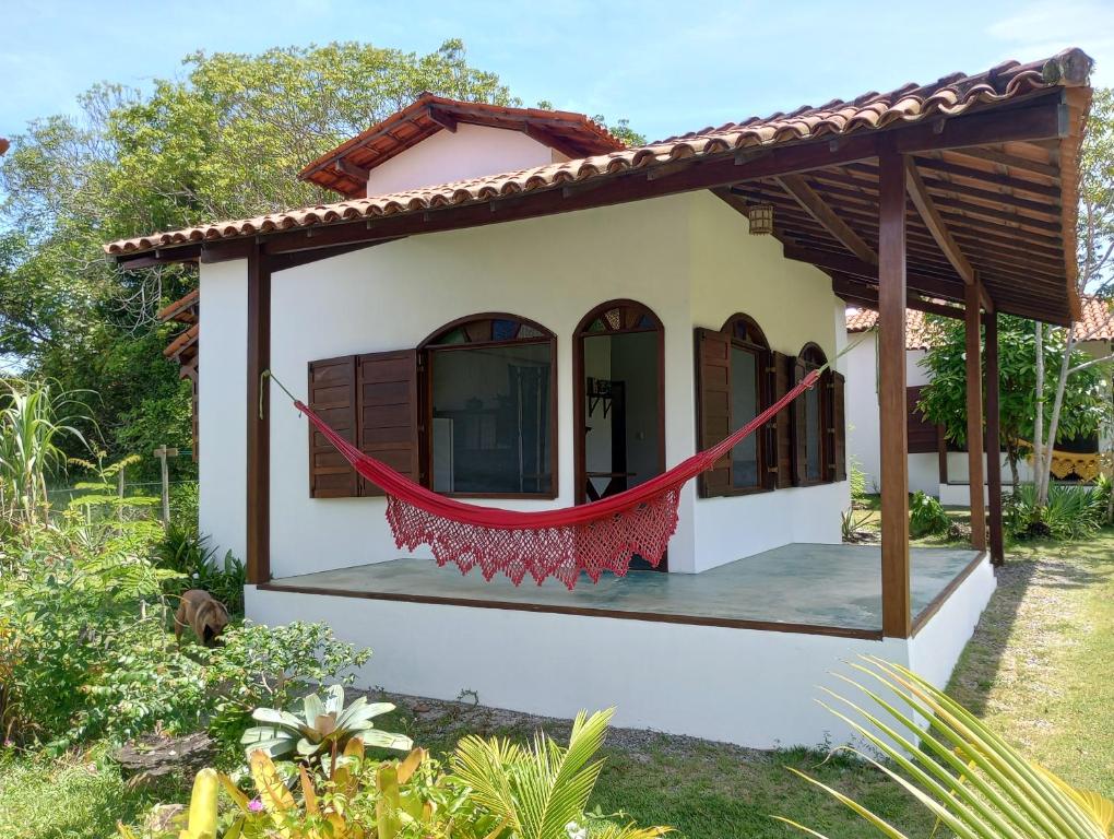 巴拉格兰德Cores do Mar Cabanas, Taipu de Fora的前面有红色吊床的小房子