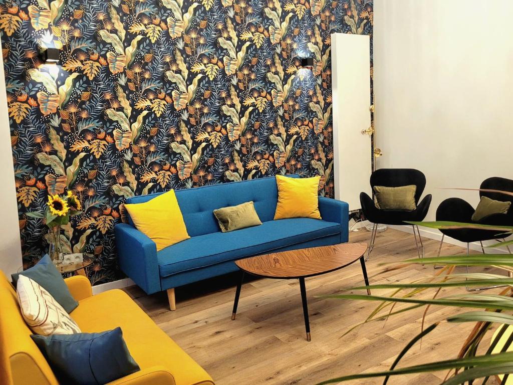 布鲁塞尔Brand new CAMELIA ROOM with private bathroom的客厅配有蓝色的沙发和花卉壁纸