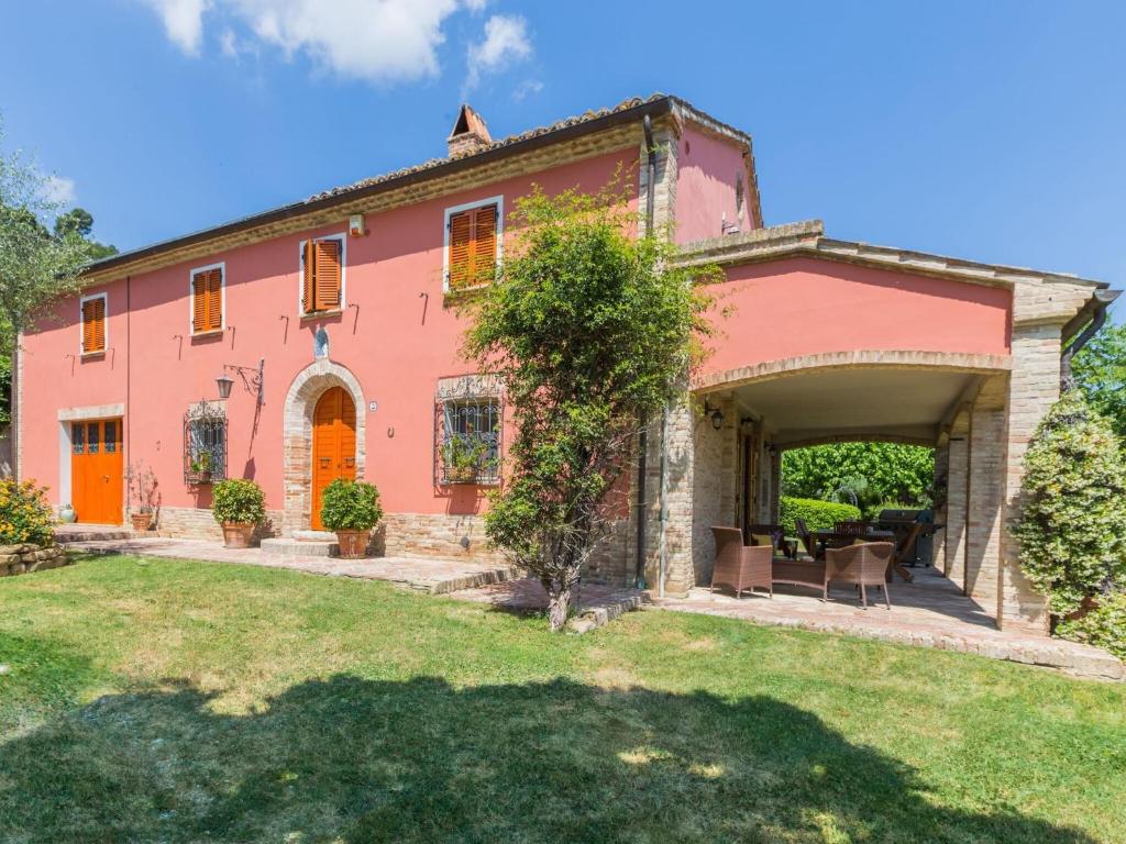 MondavioBelvilla by OYO Villa Azzurra的一座带庭院的大型粉红色房屋