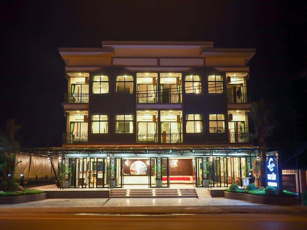 Ban Nua Khlongโรงแรมชลาลัย กระบี่ Chalalai Hotel Krabi的一座高大的建筑,在晚上有灯在前面