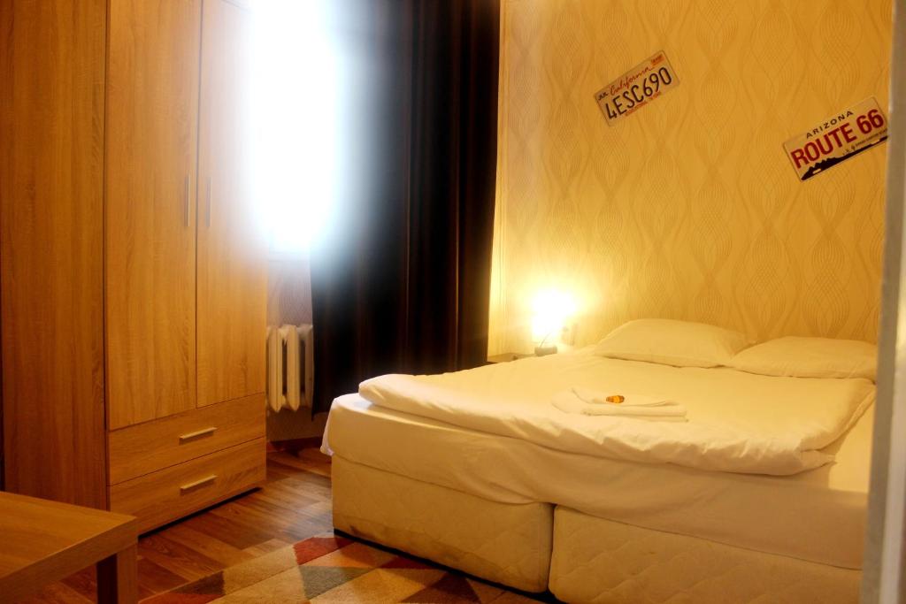 索非亚Hotello的卧室配有白色的床,墙上有标志