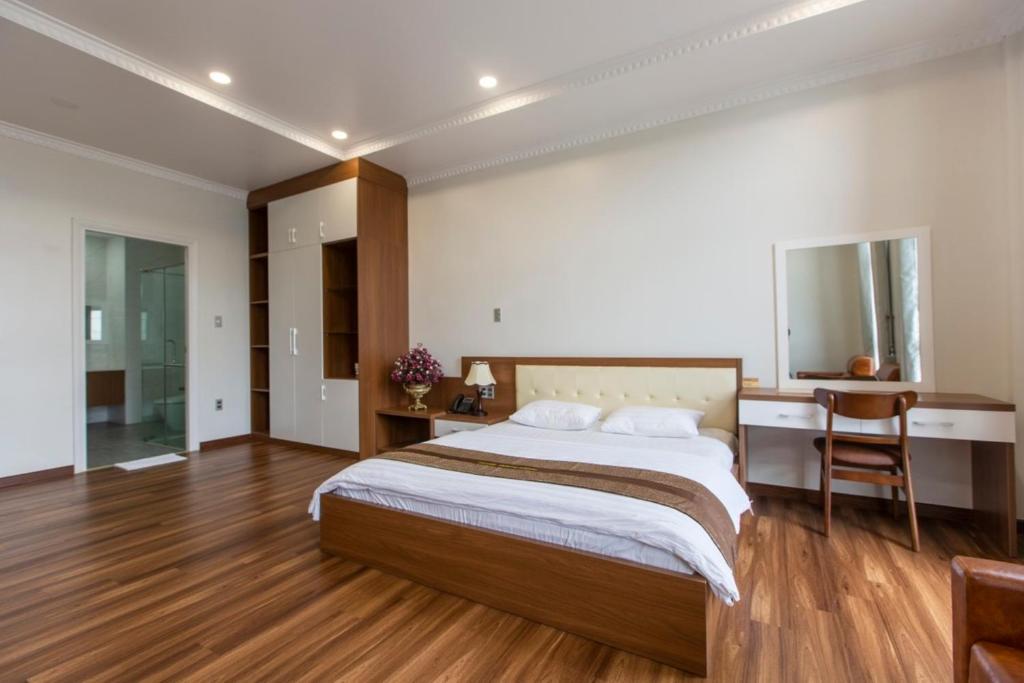 Dĩ AnHoang Hung Hotel的一间卧室配有一张大床和一张书桌