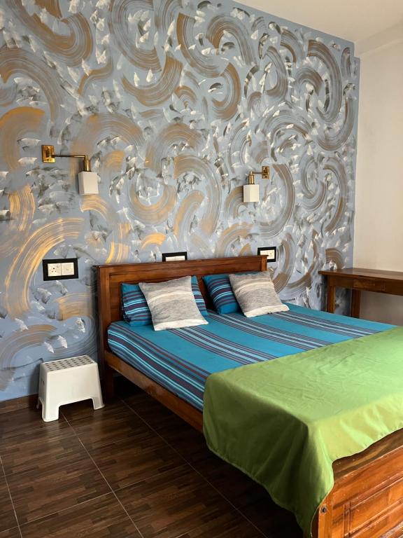 阿杭格默Ruwan Villa Ahangama的一间卧室配有一张床和壁画墙