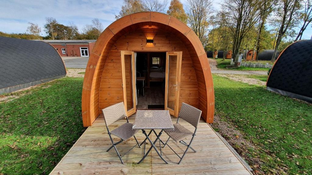Silberstedt09 Premium Camping Pod的小型木制结构,配有两把椅子和一张桌子