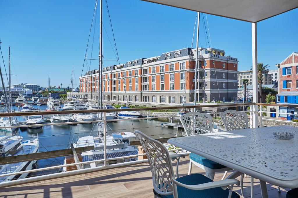 开普敦African Elite Waterfront的阳台配有桌椅和码头
