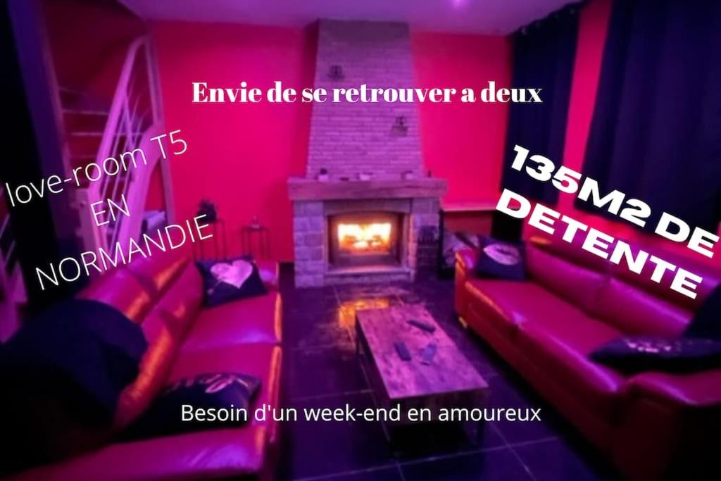 BellencombreAu nid d'amour的客房设有沙发和带粉红色灯的壁炉。