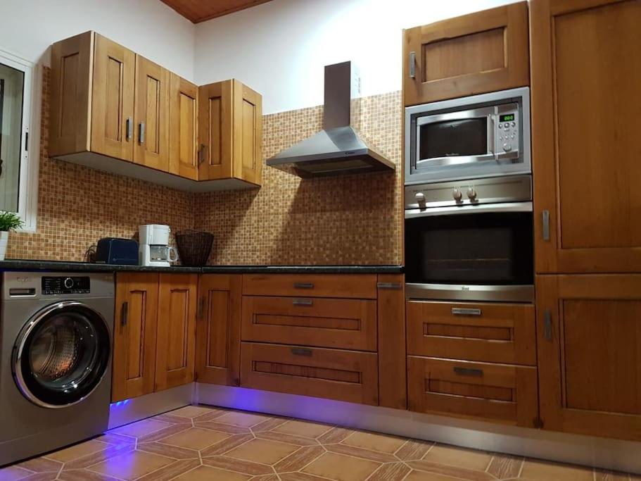 罗萨里奥港Apartamento rural zona céntrica isla的厨房配有木制橱柜、洗衣机和微波炉