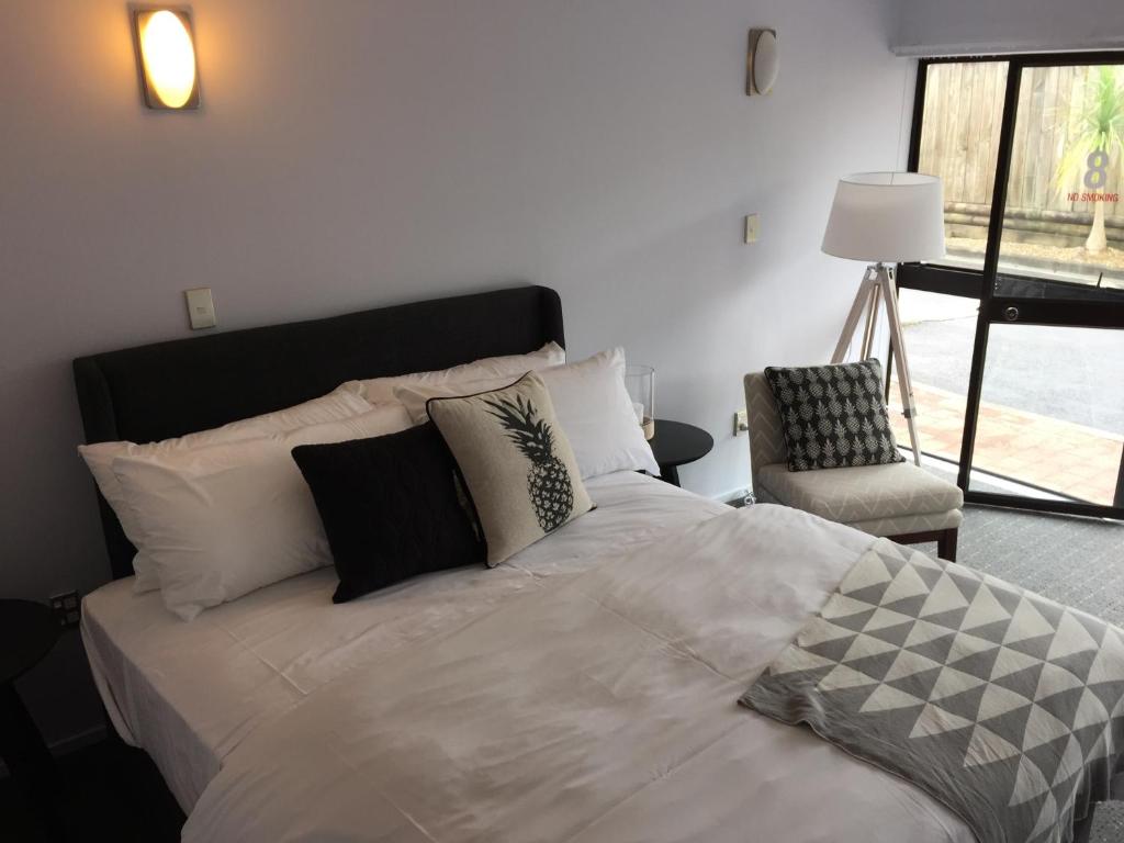 奥克兰安扎克庭院汽车旅馆的一间卧室配有一张大床和一把椅子