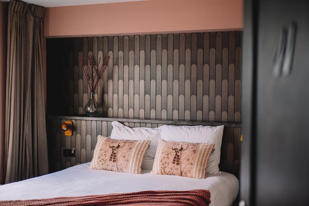 赞德沃特Boutique Lodge Zandvoort的卧室配有一张带白色床单和枕头的大床。