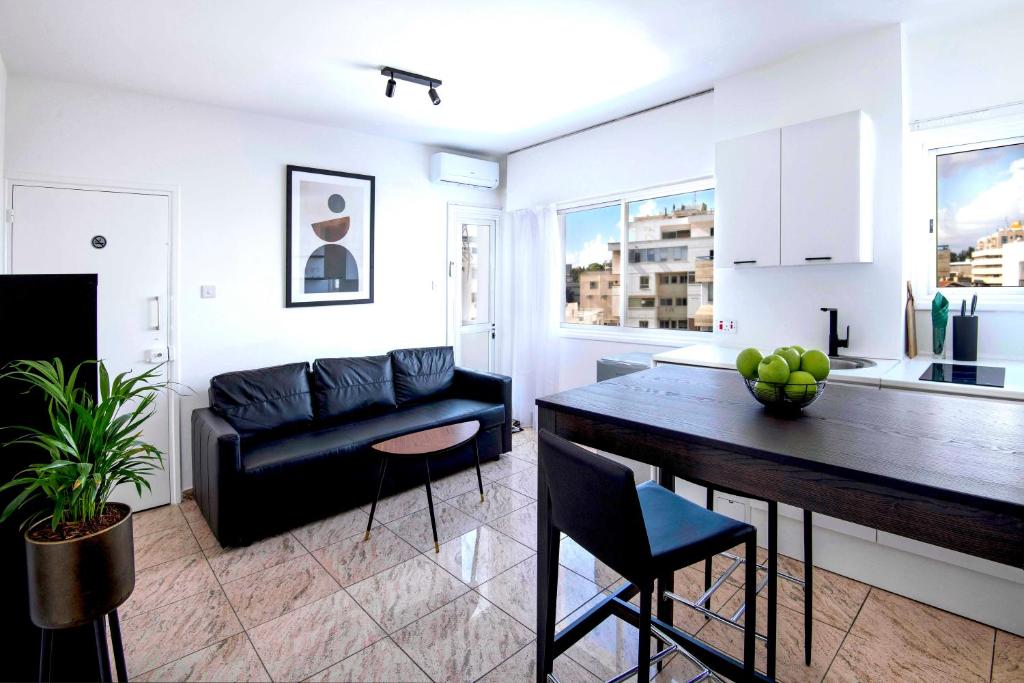 尼科西亚Urban Condo 43 - 1 Bdr的厨房以及带桌子和沙发的客厅。