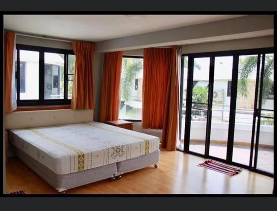 Ban Khlong Khotบ้านนาวาภิรมย์ ชะอํา的一间卧室设有一张大床和大窗户