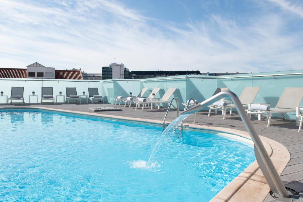 里斯本SANA酒店的一座建筑顶部的游泳池,上面有一个喷泉