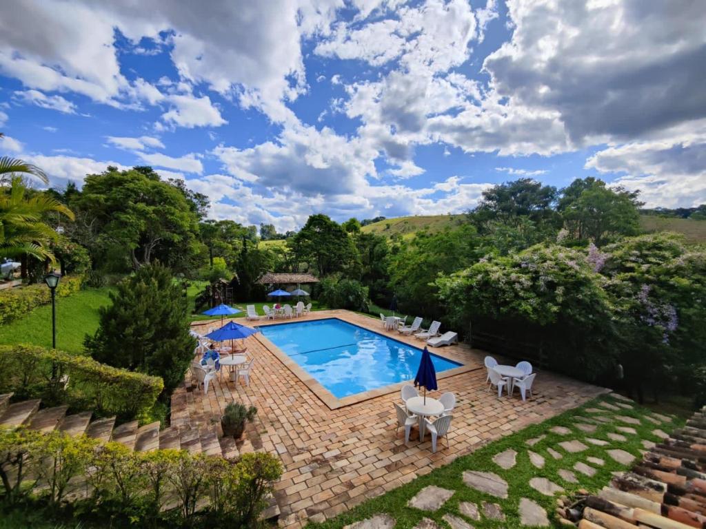卡尚布Chalés de Minas Hotel Fazenda的享有庭院游泳池的顶部景色