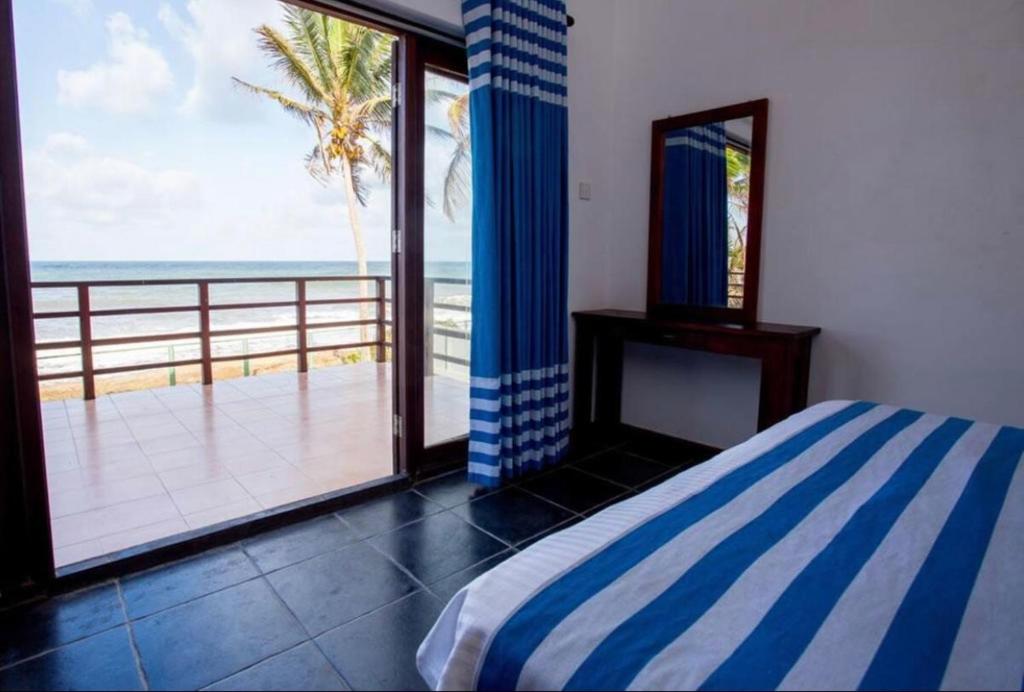PamunugamaReef Bungalow Hotel的一间卧室配有一张床,享有海景