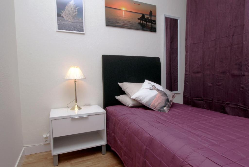 厄斯特松德杰姆特兰迪尔住宿加早餐酒店的一间卧室配有紫色的床和带台灯的床头柜。