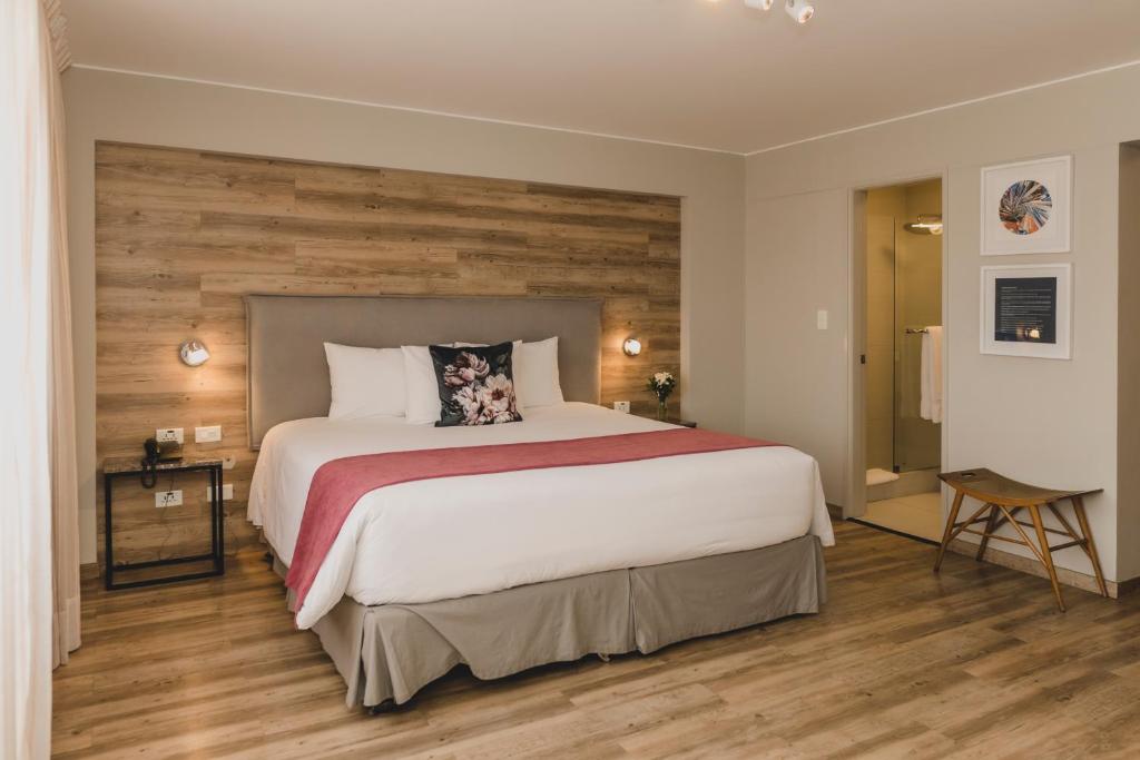 利马ARTE HOTEL Lima的一间卧室设有一张带木墙的大床
