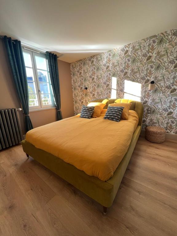 埃斯帕利翁Maison d'hôtes de la prison en toutes libertés的卧室配有一张带黄色床单和枕头的大床。