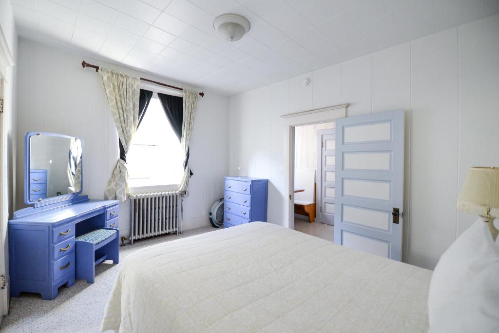 西沃德Brown & Hawkins Historical Apartments的卧室配有白色的床和蓝色梳妆台