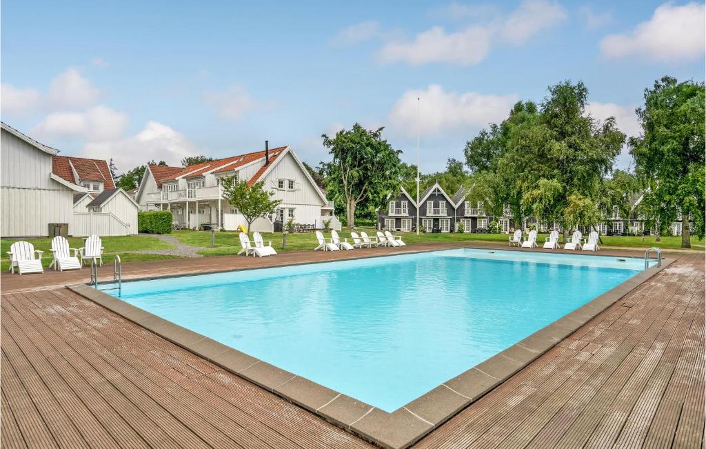 勒维Cozy Apartment In Nykbing Sj With Outdoor Swimming Pool的一个带白色椅子的游泳池以及一座房子