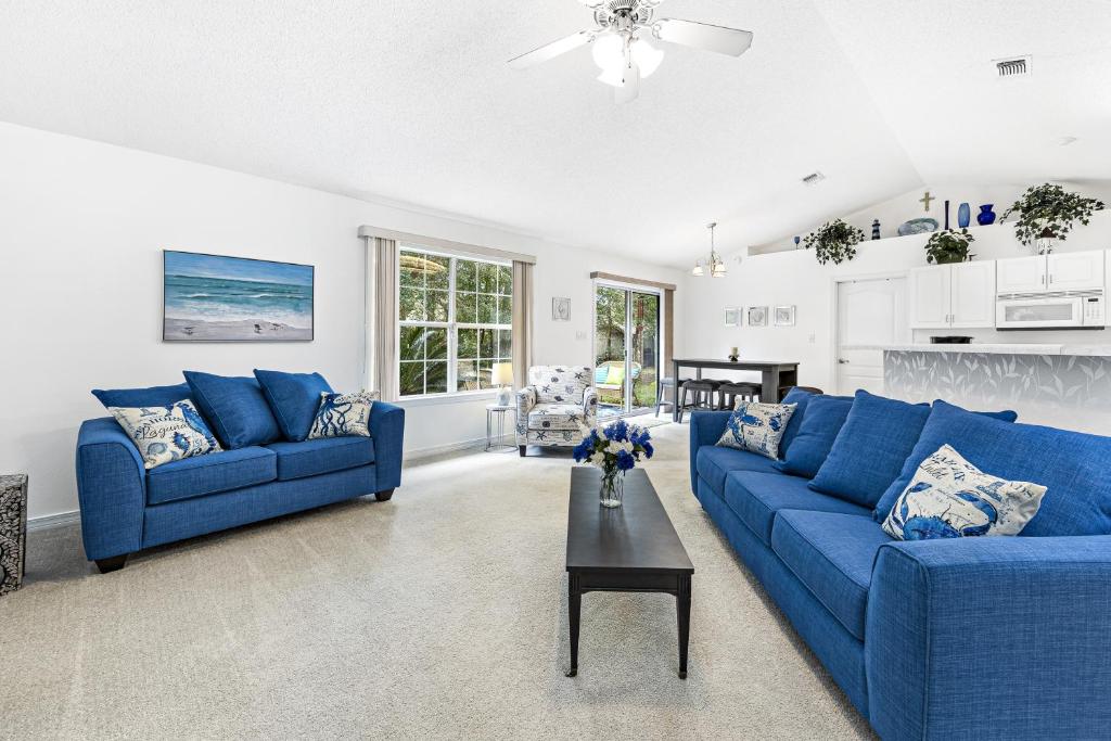 佩尔迪多海滩Charming Pensacola House with All Needed Essentials的客厅配有2张蓝色的沙发和1张桌子