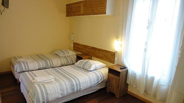 蒙鲁日巴黎蒙鲁日莫里哀酒店的小型客房 - 带2张床和窗户