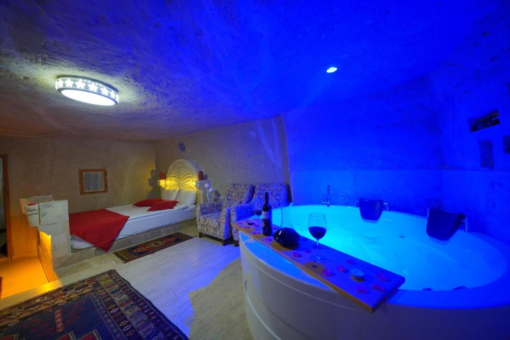 奥塔希萨尔化石洞酒店的带浴缸的浴室和1间带1张床的卧室
