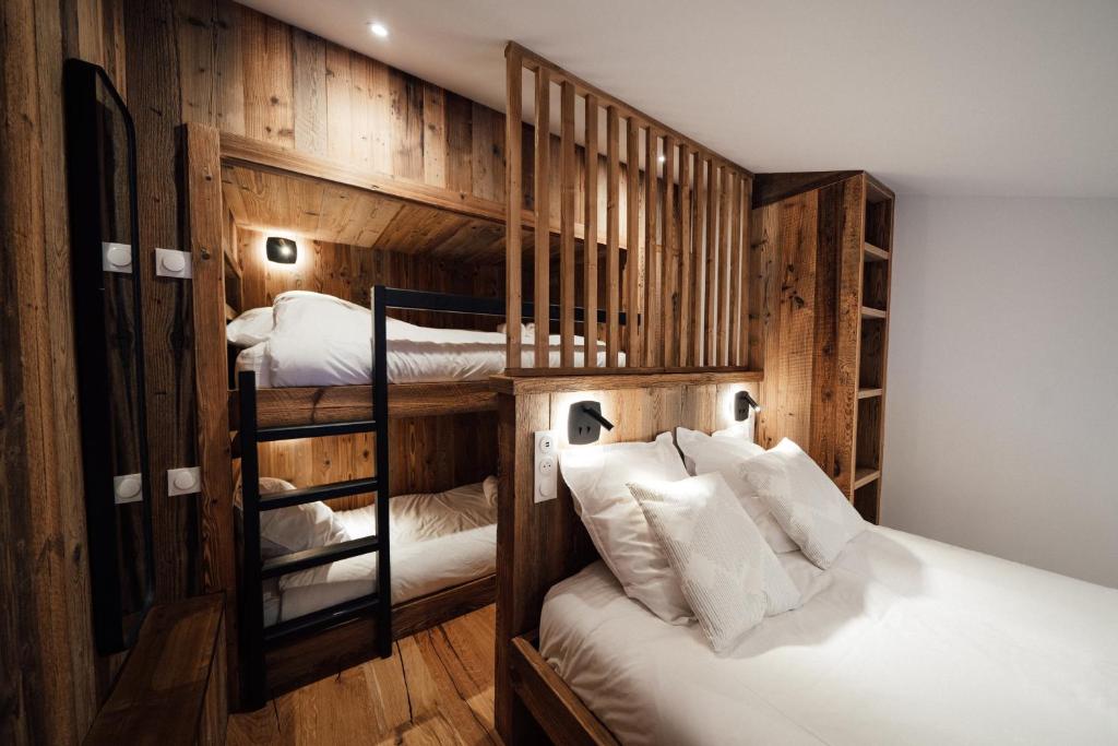 蒂涅Studio Interlude by ExplorHome的一间卧室设有两张双层床和木墙