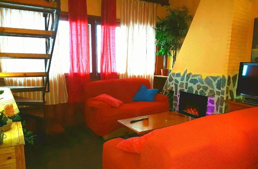 塞拉内华达Apartment de las Nieves的客厅配有2把红色椅子和电视