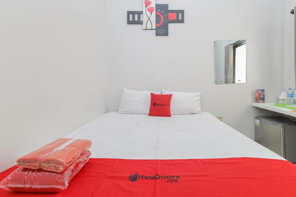 泗水RedDoorz Plus At K23 Rungkut Madya的一张白色的大床,上面有红色枕头