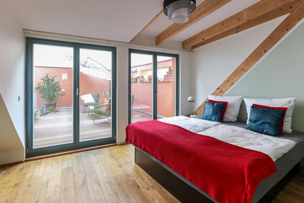 魏玛BohnApartments Bauhaus - absolutes Zentrum - Parkplatz - Vollausstattung - WLAN的一间卧室配有一张带红色毯子的大床