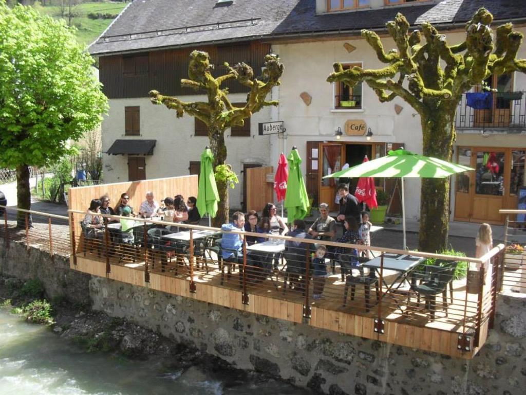 Saint-Pierre-dʼEntremontGITE AUBERGE L'HERBE TENDRE的一群人坐在大楼前的桌子上