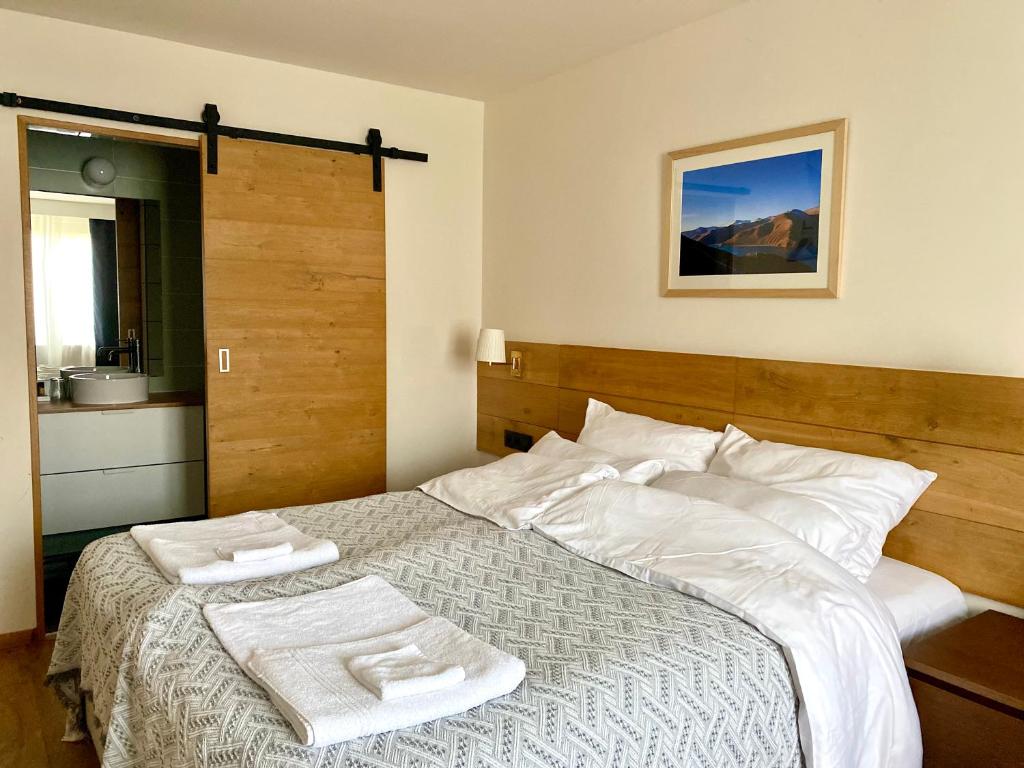 夫洛雷恩Dharma City的一间卧室配有一张床,上面有两条毛巾