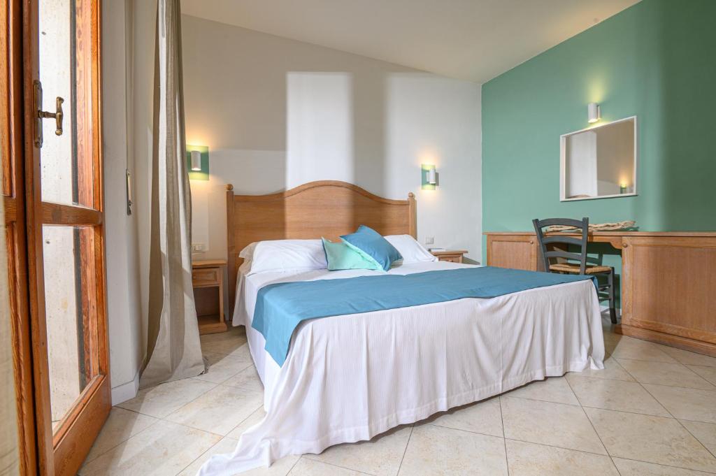坎普码头伊尔巴玛莉娜迪坎普酒店的一间卧室配有一张带蓝色床单的床和一张桌子。