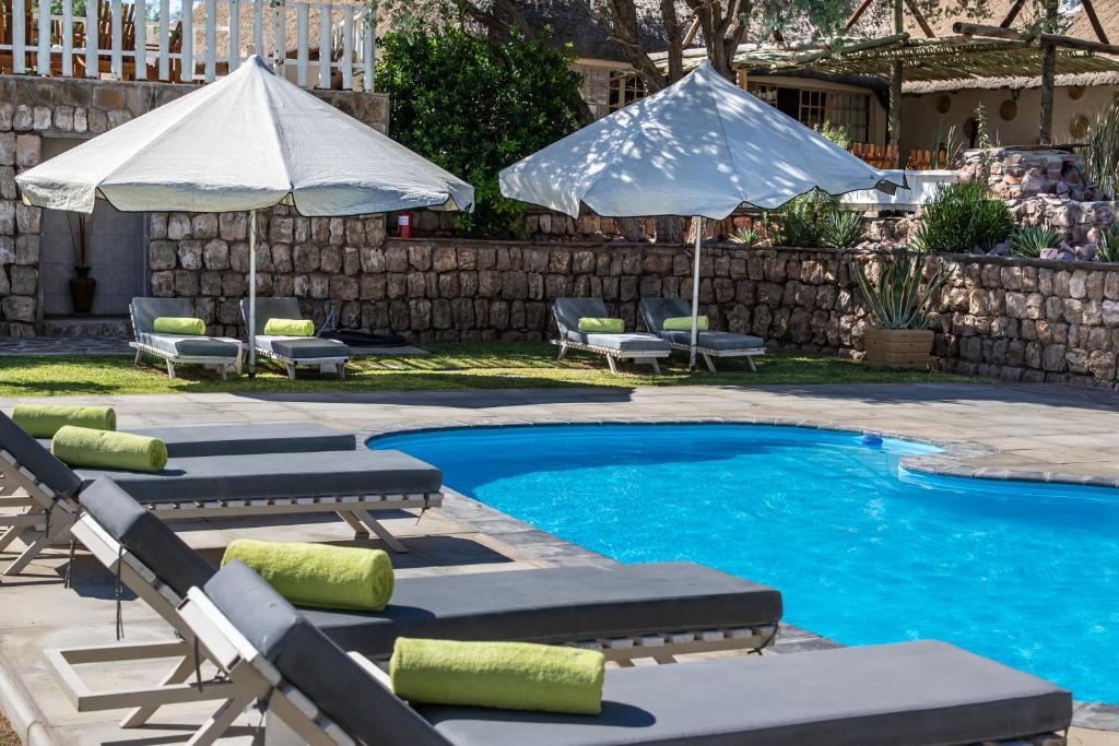 塞斯瑞姆Elegant Desert Lodge的一个带躺椅和遮阳伞的游泳池