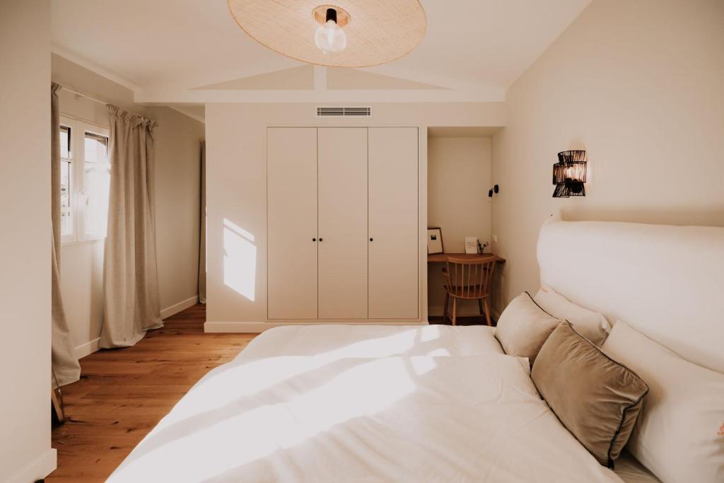 居让梅斯特拉Chez Brens - Maison d'hôtes à La Hume的卧室配有白色的床和白色橱柜