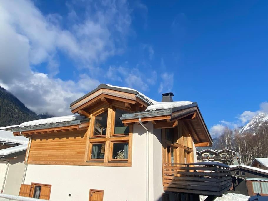 夏蒙尼-勃朗峰Chalet Isabella : cozy & comfy in central Chamonix的一座有木屋顶的房子,上面有雪