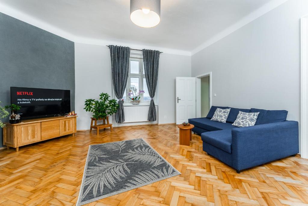 布拉格Alla Prague Apartment的客厅配有蓝色的沙发和电视
