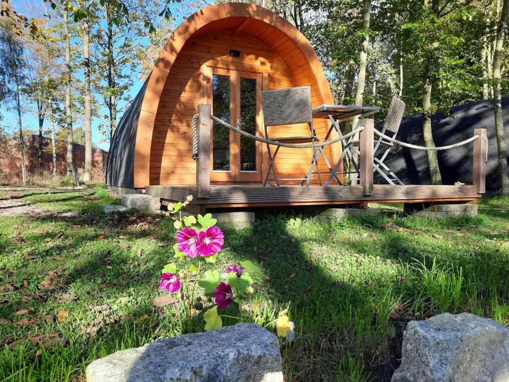 Silberstedt29 Premium Camping Pod的小木屋,配有椅子,位于草地上