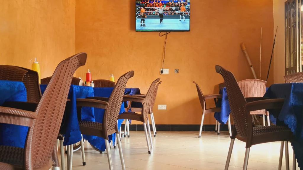 恩德培Haber Motel Enterprise Ltd的一间配备有蓝色桌椅和电视的用餐室