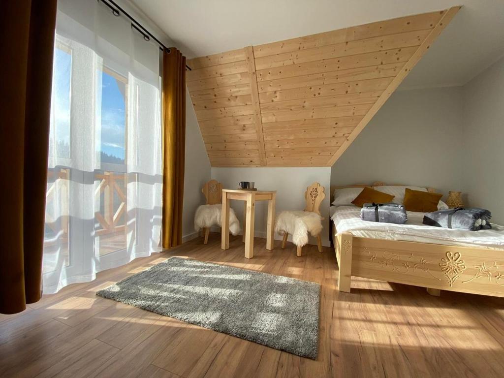 斯派特克维瑟Willa Pod Wyciągiem的一间卧室设有一张床和一个大窗户