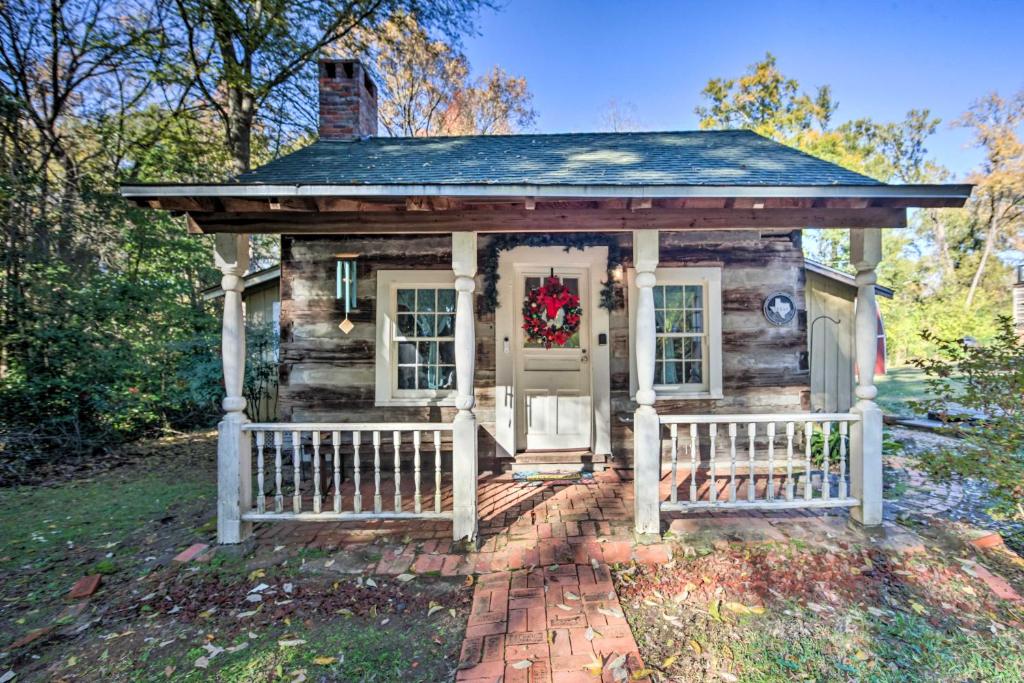 马绍尔Historic Marshall Log Cabin Less Than 1 Mi to Dtwn!的门上戴着圣诞花圈的小房子