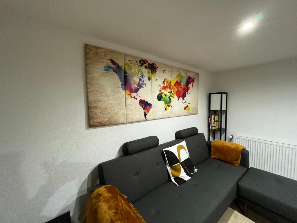 Village-NeufChouett'Appart proche frontières的客厅配有沙发和墙上的地图